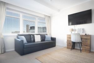 a living room with a couch and a large window at Sunset Apartment - 7th Floor Double Tree in Brighton & Hove
