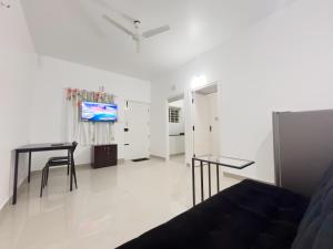 a living room with two tables and a flat screen tv at The Pinnacle - Electronic City in Bengaluru