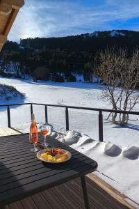 a table with a plate of food and two glasses of wine at Chalet Prestige - Ski au pieds - Les Angles in Les Angles
