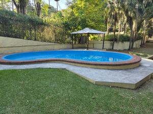 una piscina in un cortile con ombrellone di Casa Al pie del Cerro a Yerba Buena