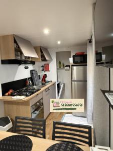 a kitchen with stainless steel appliances and a table and chairs at L'Escapade Seignossaise in Seignosse