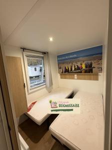 a small room with two beds and a window at L'Escapade Seignossaise in Seignosse