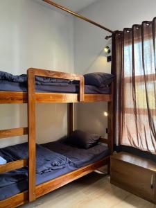 a room with three bunk beds in a hostel at Kali Code Home in Yogyakarta