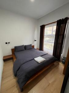 a bedroom with a large bed with a window at Kali Code Home in Yogyakarta +36 photos