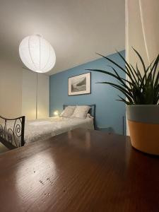 Un dormitorio con una cama y una mesa con una planta en maceta. en Chambre cosy entre ville et campagne, en Lorette