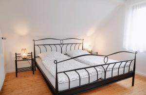 a bedroom with a black metal bed with two lamps at Ferienwohnung Alte Scheune in Westerburg