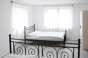 a bed in a room with white walls and windows at Ferienwohnung Alte Scheune in Westerburg