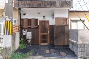 a house with a wooden door and a fence at 蛮子民宿 金閣寺 in Kyoto