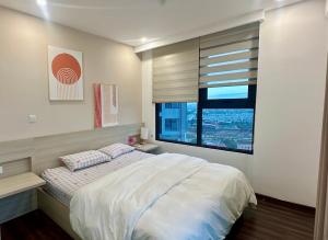a bedroom with a large bed and a window at Sunmie Home Hoàng Huy Commerce Apartment in Hai Phong