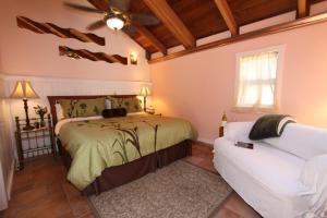 ein Schlafzimmer mit einem Bett und einem weißen Sofa in der Unterkunft Elk Cove Inn & Spa in Elk