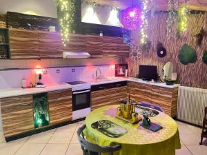 Una cocina con una mesa con una tetera encima. en Un Mirage Tropical - Bulles , Spa & Détente en Bord de Loire, en Saint-Clément-des-Levées
