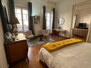 una camera da letto con un letto con una coperta gialla sopra di Escale citadine au centre d'Avignon, climatisation, appartement de charme, spacieux et lumineux ad Avignone