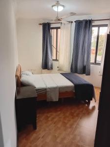 Un dormitorio con una cama grande con cortinas azules. en VERA's TOWERS, en Accra