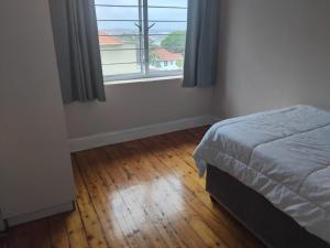 Harbour View Villas - Durban في ديربان: غرفة نوم بها سرير ونافذة كبيرة