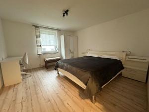 Steinbach am WaldApartment Lale的一间卧室，配有一张床、一张书桌和一扇窗户