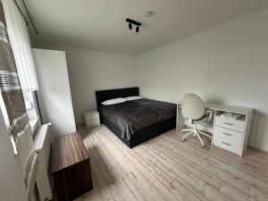 Steinbach am WaldApartment Lale的一间卧室，配有一张床、一张桌子和一把椅子