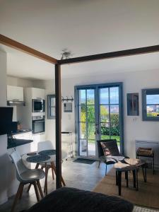 a living room with a couch and a table at Bel Air Studios-Terrasse couverte-Jardinet-Vue Pont de Normandie-Parking privé in Honfleur