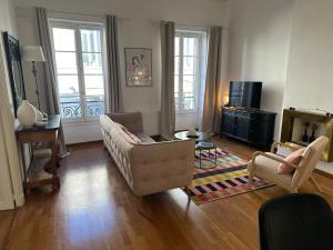 un soggiorno con un divano e una poltrona di Escale citadine au centre d'Avignon, climatisation, appartement de charme, spacieux et lumineux ad Avignone