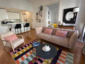 un soggiorno con un divano e un tavolo di Escale citadine au centre d'Avignon, climatisation, appartement de charme, spacieux et lumineux ad Avignone