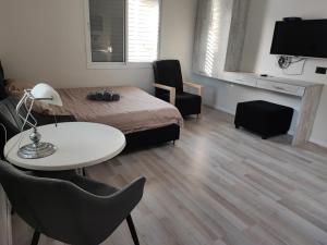 a bedroom with a bed and a table and chairs at pinsker apartment city center in Petaẖ Tiqwa +1 photo