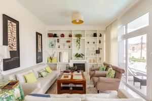 a living room with white furniture and a fireplace at Escape To your Private Pool, Sea Views and Bbq in Jinámar