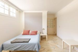 a white bedroom with a bed with red pillows at Escape To your Private Pool, Sea Views and Bbq in Jinámar +48 photos