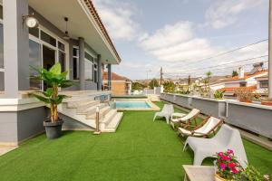 a backyard with green grass and a swimming pool at Escape To your Private Pool, Sea Views and Bbq in Jinámar