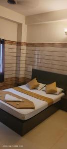 Una cama con dos almohadas encima en una habitación. en Yammuna Vihaar Tourist Home, en Kollūru