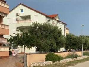 Un edificio blanco con un árbol delante. en MP More, en Srima
