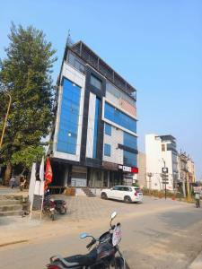 The Crims Hotel Jaipur في جايبور: سكوتر متوقف أمام مبنى