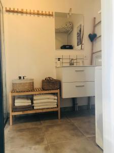 a bathroom with a sink and a shelf with towels at Bel Air Studios-Terrasse couverte-Jardinet-Vue Pont de Normandie-Parking privé in Honfleur +31 photos