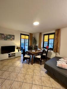a living room with a table and chairs and a television at Ferienwohnungen Rehn in Dresden