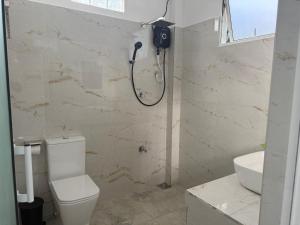 a bathroom with a shower and a toilet and a sink at Seaview Mountain Villa in Mirissa
