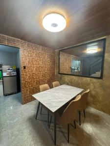 a dining room with a table and chairs and a brick wall at Casa Maria Guest House in Angeles