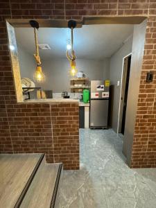 a kitchen with a refrigerator and a brick wall at Casa Maria Guest House in Angeles +3 photos