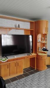 a large entertainment center with a large flat screen tv at Enumo House in Itapoa +16 photos