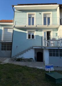 Bagnolo PiemonteにあるAzzurraの階段とバルコニー付きの白い建物