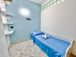 a blue room with a bed with a teddy bear on it at Casa Francesco Seaside in Sant'Angelo D'Ischia