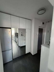 a kitchen with white cabinets and a white refrigerator at Casa Serena in Odorheiu Secuiesc