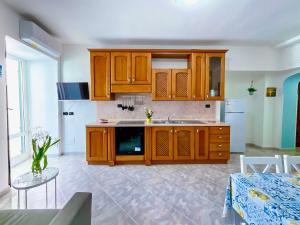 a kitchen with wooden cabinets and a table in a room at Casa Francesco Seaside in Sant'Angelo D'Ischia