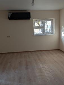 una stanza vuota con finestra e pavimento in legno di Cozy Home a Balaovit