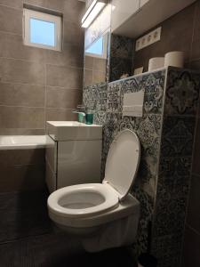 a bathroom with a white toilet and a sink at Casa Serena in Odorheiu Secuiesc +2 photos