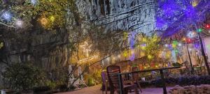 a stone wall with lights and a table and chairs at Sun Mountain Hostel in Nguyên Ngoại