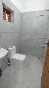a white bathroom with a toilet and a sink at Clay Canvas in Anachal