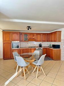 a kitchen with wooden cabinets and a table and chairs at Apartment Meringa in Pettenasco