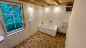 a bathroom with a bath tub and a window at Brzozowe Rancho in Lublinów