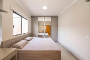 una camera da letto con un letto grande e una finestra di Casa Munique Maringa a Maringá Altre 25 foto