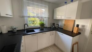 a kitchen with white cabinets and a black counter top at Ferienwohnung Lilienthal in Lilienthal