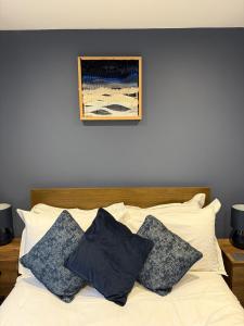 a bedroom with a white bed with pillows on it at The Ship Inn's Mill Cottage - Weavers Way in Gatehouse of Fleet