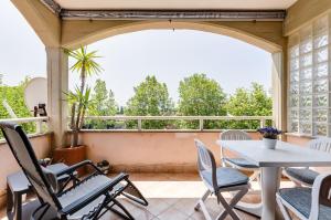 a porch with chairs and a table and a window at Appartamento vista mare, 100mt dall'Ospedale Pediatrico, a 200mt dal mare, 1h da Roma Termini in Santa Marinella